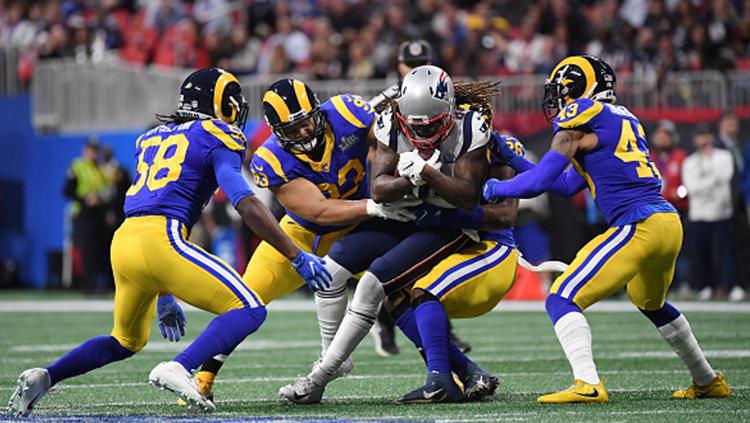 Cordarrelle Patterson (jersey putih) dipaksa empat pemain Los Angeles Rams untuk mengeluarkan bola dari genggamanya