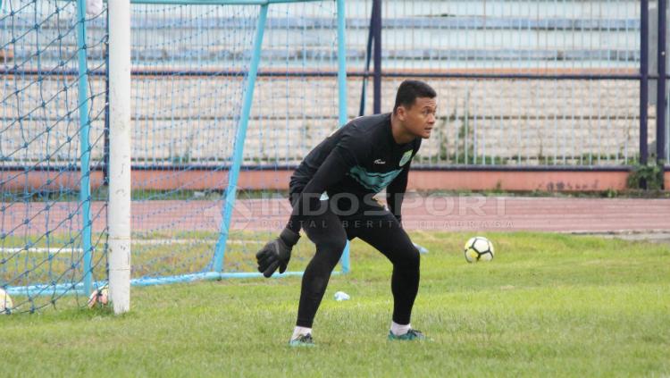 Dian Agus Prasetyo melakukan pemanasan sebelum latihan di Stadion Surajaya, Lamongan, Senin (10/02/19).