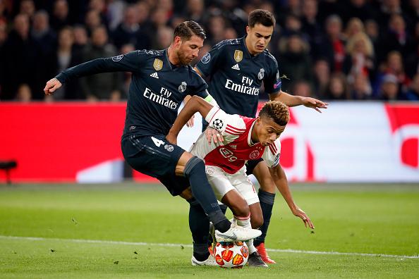 Sergio Ramos (Real Madrid/kiri) saat mencoba menahan laju dari pemain Ajax Amsterdam, David Neres. Copyright: INDOSPORT