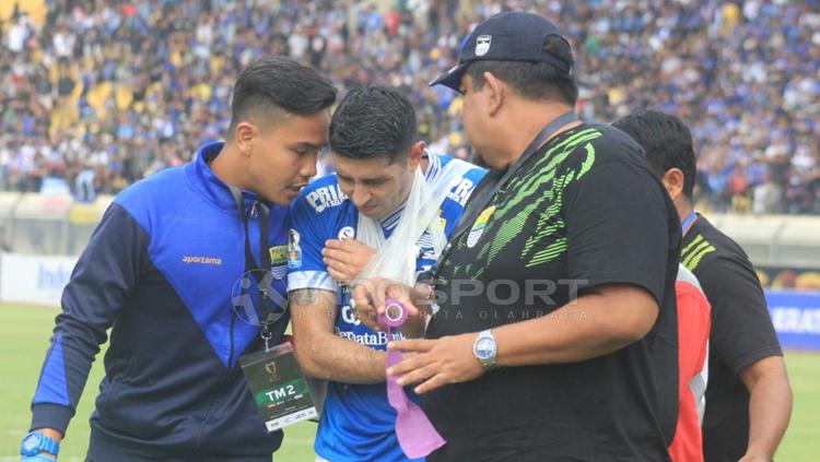 Bintang Persib Bandung Esteban Vizcarra mendapatkan perawatan dari tim medis.