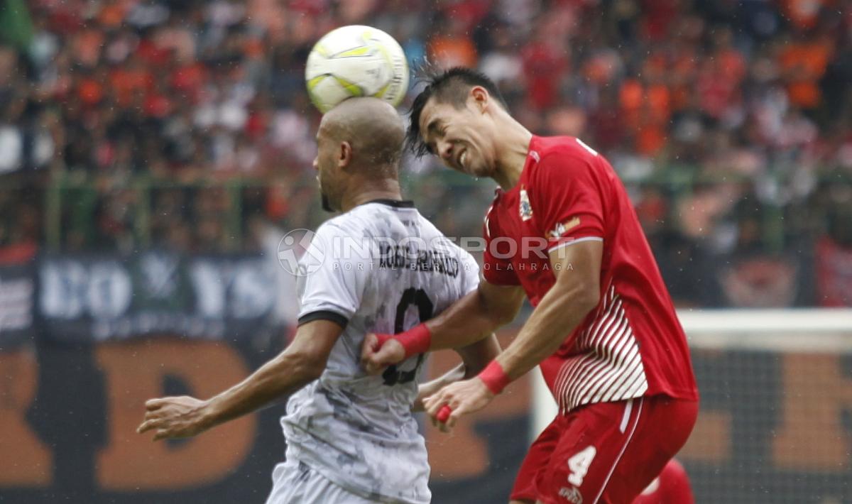 Ryuji Utomo (kanan) saat duel udara dengan striker PS Tira, Loris Arnaud pada leg kedua babak 16 besar Piala Indonesia di stadion Patriot, Kamis (21/02/18).