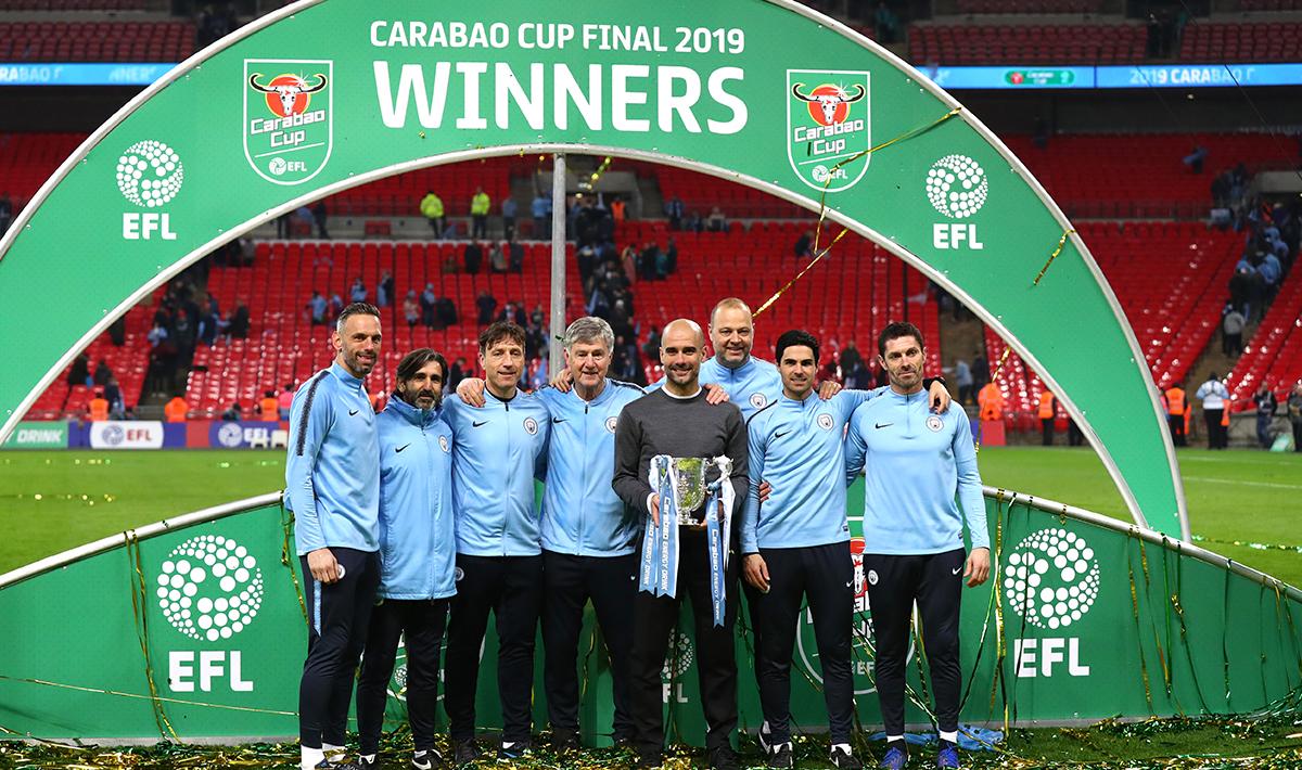 Josep Guardiola dan jajaran pelatih Man City melakukan foto bersama trofi Piala Liga Inggris