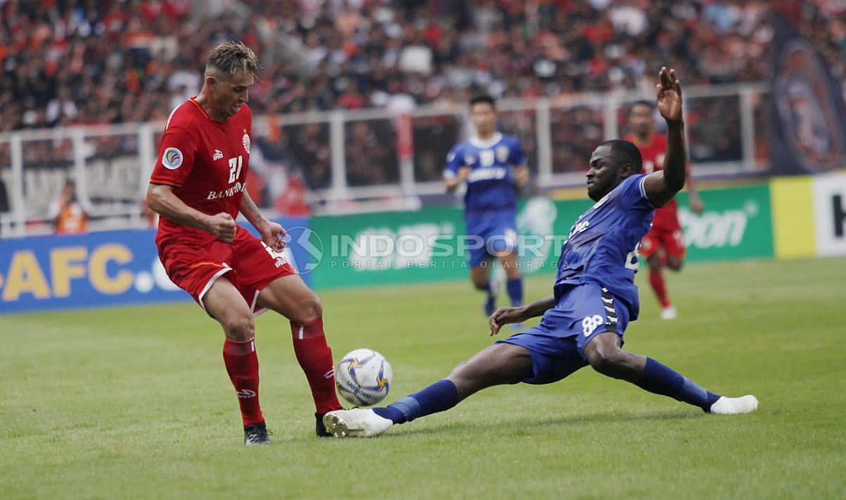 Bek Becamex Binh Duong, Ali Rabo (kanan) melayangkan tekel keras ke arah Silvio Escobar (kiri) pada laga perdana Piala AFC 2019 grup G di stadion GBK, Selasa (26/02/18). Copyright: Herry Ibrahim/INDOSPORT