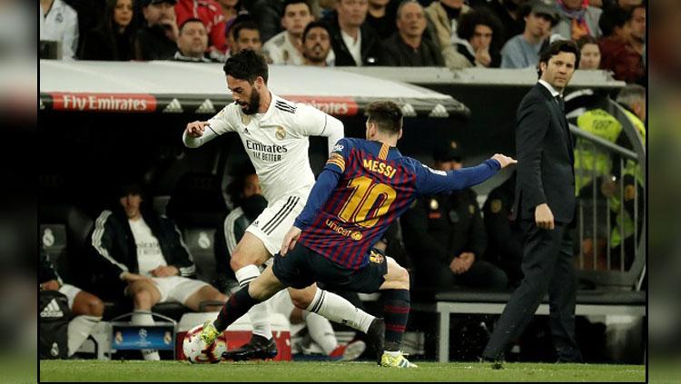 Pergerakkan dari gelandang serang Real Madrid, Isco dijegal oleh pemain megabintang Barcelona, Lionel Messi.