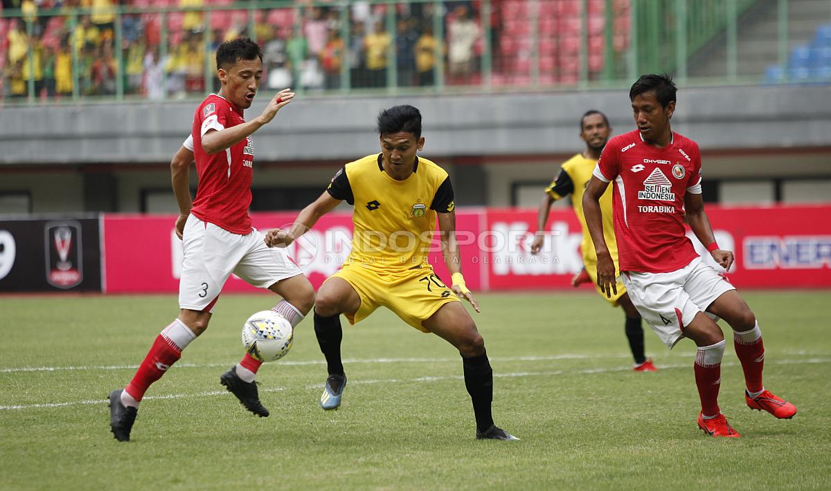 Pemain BFC, Dendy Sulistyawan (kedua kiri) dijaga dua pemain Semen Padang Syaiful Indra Cahya dan Shukurali Pulatov Padang pada laga perdana grup B Piala Presiden 2019 di stadion Patriot, Minggu (03/03/19).