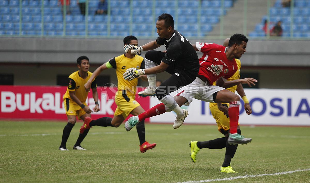 Duel antara kiper BFC, Wahyu Tri Nugroho (tengah) dengan striker Semen Padang pada laga perdana grup B Piala Presiden 2019 di stadion Patriot, Minggu (03/03/19). - INDOSPORT