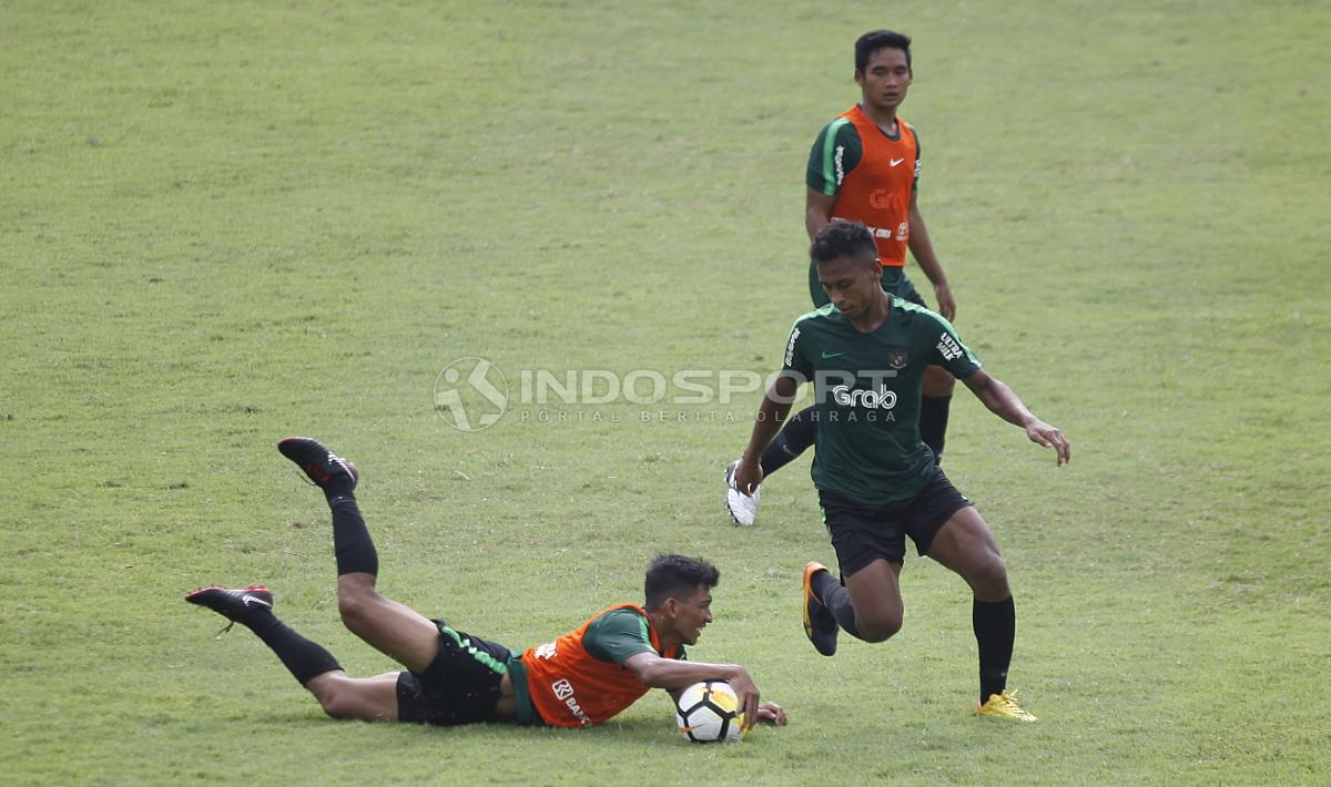 Teuku Muhammad Ichsan (kiri) terjatuh saat mencoba merebut bola dari Osvaldo Haay pada internal game Timnas U-23 di stadion Madya, Senayan, Sabtu (09/03/19).