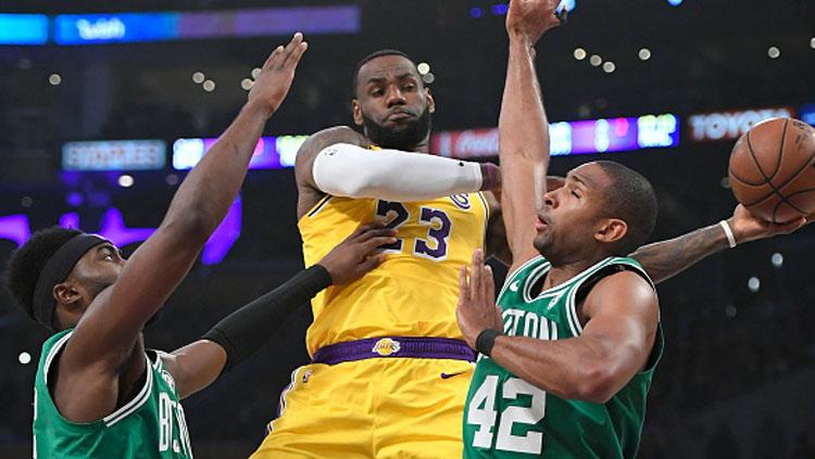 Pemain megabintang LA Lakers, LeBron James dijaga ketat oleh 2 pemain bintang Boston Celtics. Copyright: INDOSPORT