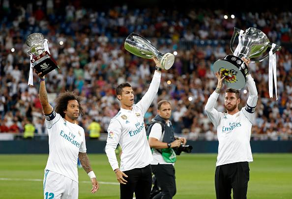 Marcelo (kiri), Cristiano Ronaldo (tengah), dan Sergio Ramos saat sama-sama mengangkat trofi untuk Real Madrid. Copyright: INDOSPORT