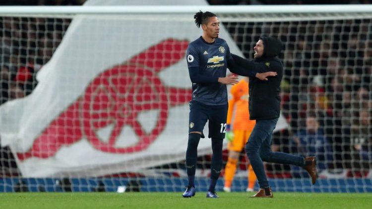 Fans Arsenal yang menerobos masuk lapangan mendekati Chris Smalling