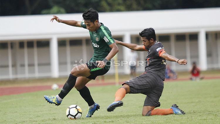 Pemain Timnas U-23, Hanif Sjahbandi (kiri) dijaga ketat oleh pemain Semen Padang pada laga uji coba di stadion Madya Senayan, Selasa (12/03/19).