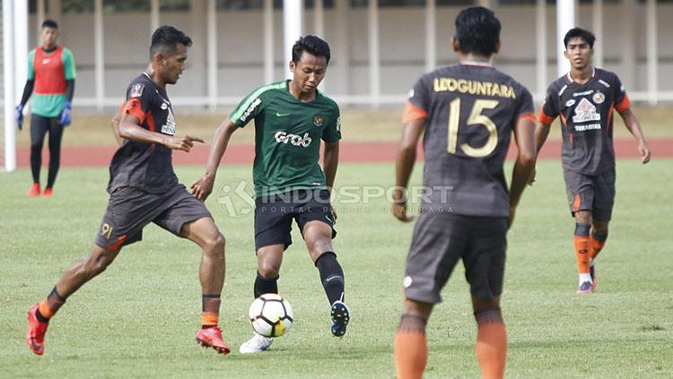 Pemain Timnas U-23, Kadek Raditya mencoba melewati hadangan pemain Semen Padang pada laga uji coba di Sstadion Madya Senayan, Selasa (12/03/19).