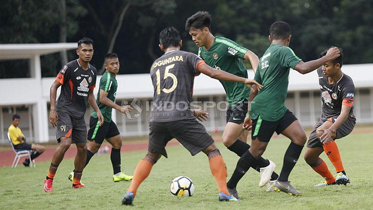 Pemain Timnas U-23, Feby Eka Putra dihadang beberapa pemain Semen Padang pada laga uji coba di Stadion Madya Senayan, Selasa (12/03/19).