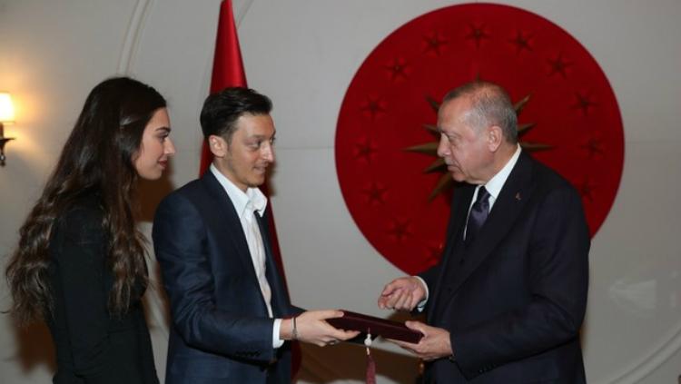 Mesut Ozil bersama sang kekasih, Amine Gulse, menyerahkan undangan pernikahan mereka pada Presiden Turki, Recep Tayyip Erdogan. - INDOSPORT