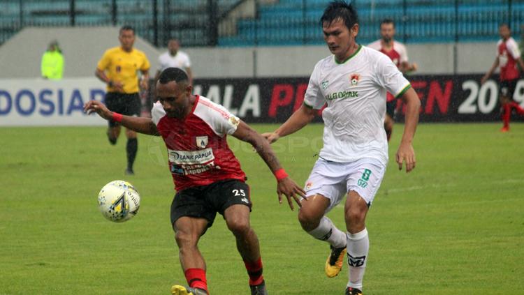 Titus Bonai melakukan pengontrolan bola dari pemain Kalteng
