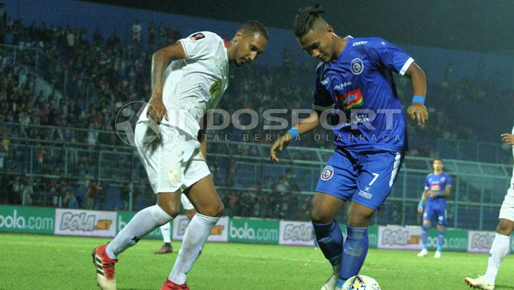 Pemain Arema FC, Ahmad Nur Hardianto (biru) saat melawan Barito Putera. - INDOSPORT