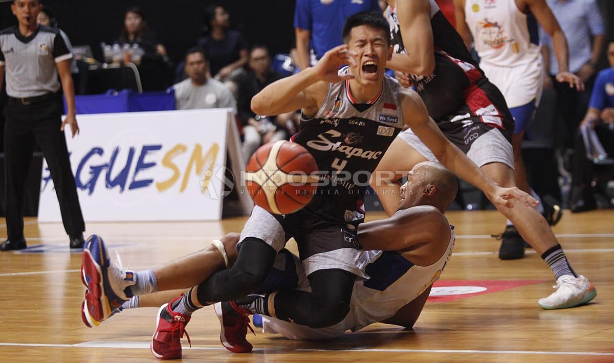 Pemain Stapac Jakarta tampak kesakitan kejatuhan pemain Satria Muda Pertama.