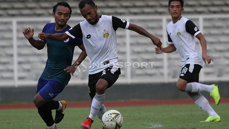 Pemain Bhayangkara FC, M Nur Iskandar (kiri) saat mencoba melewati hadangan pemain PPLM Ragunan dalam laga uji coba di Stadion Madya, Senayan, Selasa (26/03/19).