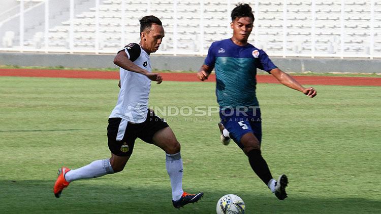 Pemain Bhayangkara FC (kiri) saat mencoba melewati hadangan pemain PPLM Ragunan dalam laga uji coba di Stadion Madya, Senayan, Selasa (26/03/19).