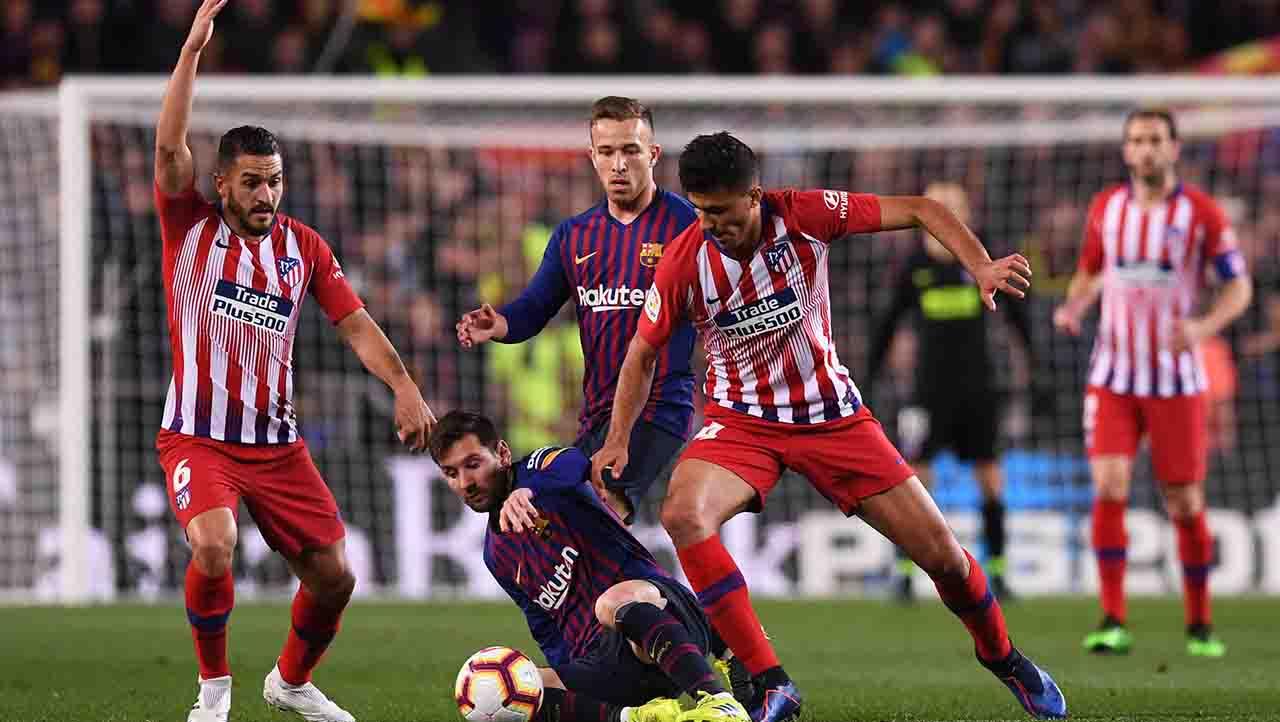 Lionel Messi berusaha keras untuk mengamankan bola dari Rodri pada laga Laliga Spanyol di Camp Nou pada Minggu (07/04/19). Alex Caparros / Getty Images