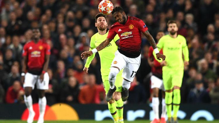 Fred saat berduel udara dengan Lionel Messi di laga Man United vs Barcelona. Copyright: Stu Forster/Getty Images