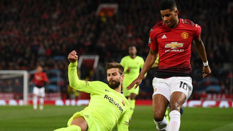 Marcus Rashford berusaha merebut bola dari kaki Gerard Pique.