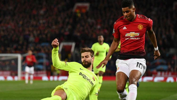 Marcus Rashford berusaha merebut bola dari kaki Gerard Pique. Copyright: Getty Images