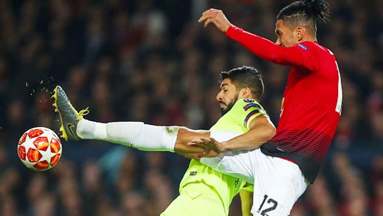 Pemain Manchester United, Chris Smalling saat berduel udara dengan Luis Suarez di laga Manchester United vs Barcelona. Foto: Robbie Jay Barratt - AMA/Getty Images