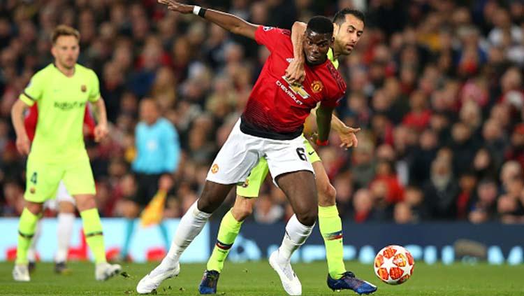 Pemain Manchester United, Paul Pogba saat berduel dengan Sergio Busquets di laga Manchester United vs Barcelona. Foto: Alex Livesey - Danehouse/Getty Images