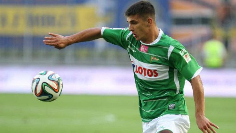 Piotr Grzelczak menguasai bola.
