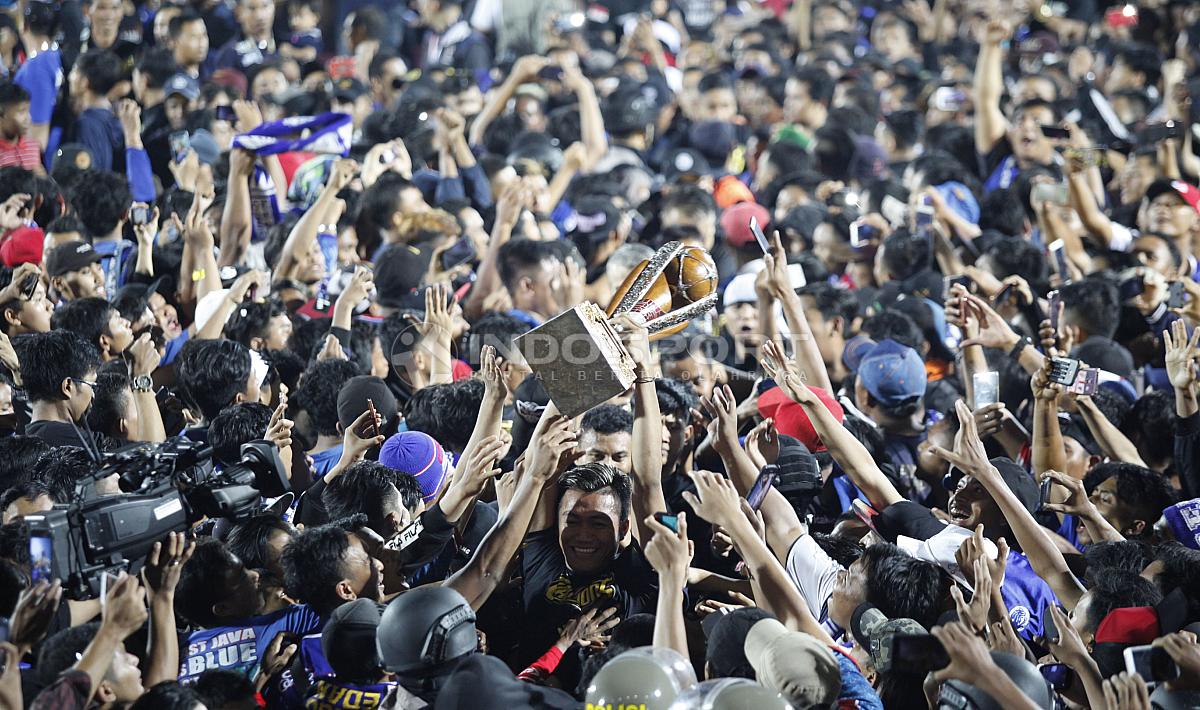 Kiper Arema FC, Utam Rusdiana saat mengangkat trophy Piala Presiden 2019 ditengah ribuan Aremania di stadion Kanjuruhan, Jumat (12/04/19).