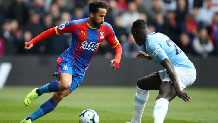 Andros Townsend (kiri) mencoba melewati hadangan Benjamin Mendy pada laga Liga Primer Inggris, Minggu (14/04/2019) (Julian Finney/Getty Images).