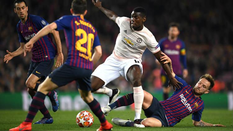 Paul Pogba berusaha untuk melindungi bola dari rebutan pemain Barcelona. Copyright: David Ramos/Getty Images