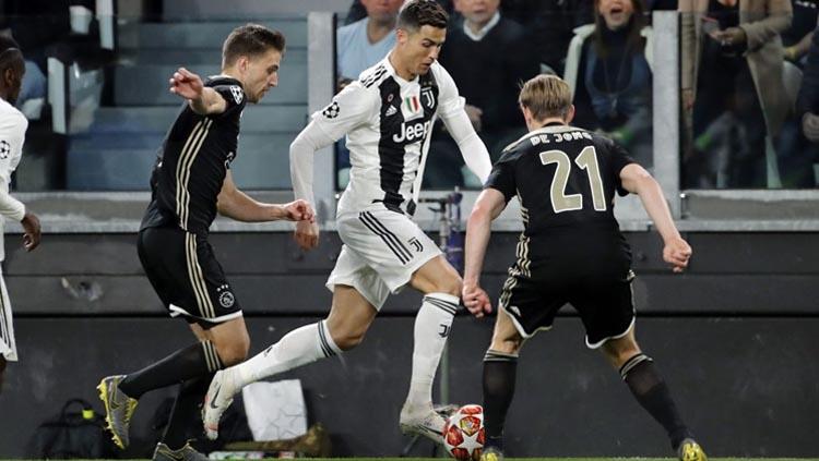 Cristiano Ronaldo saat sedang dihadang oleh pemain pertahanan Ajax. Copyright: Photo by VI Images,Getty Image