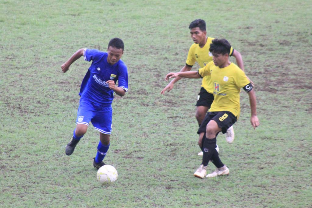 Pemain Persib U-16 dihadang dua pemain Barito Putera U-16 di laga Liga 1 U-16 2019 di Stadion Sport Jabar Arcamanik. - INDOSPORT