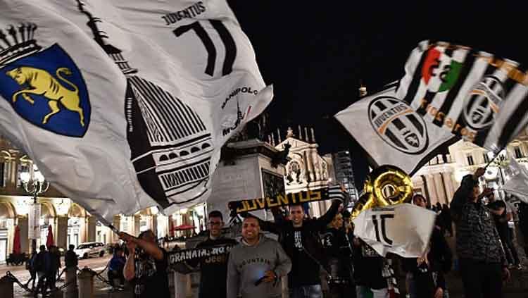 Para fans Juventus pun turut merayakan gelar juara yang diraih tim kesayangan mereka usai laga melawan Fiorentina di luar Stadion Allianz. - INDOSPORT