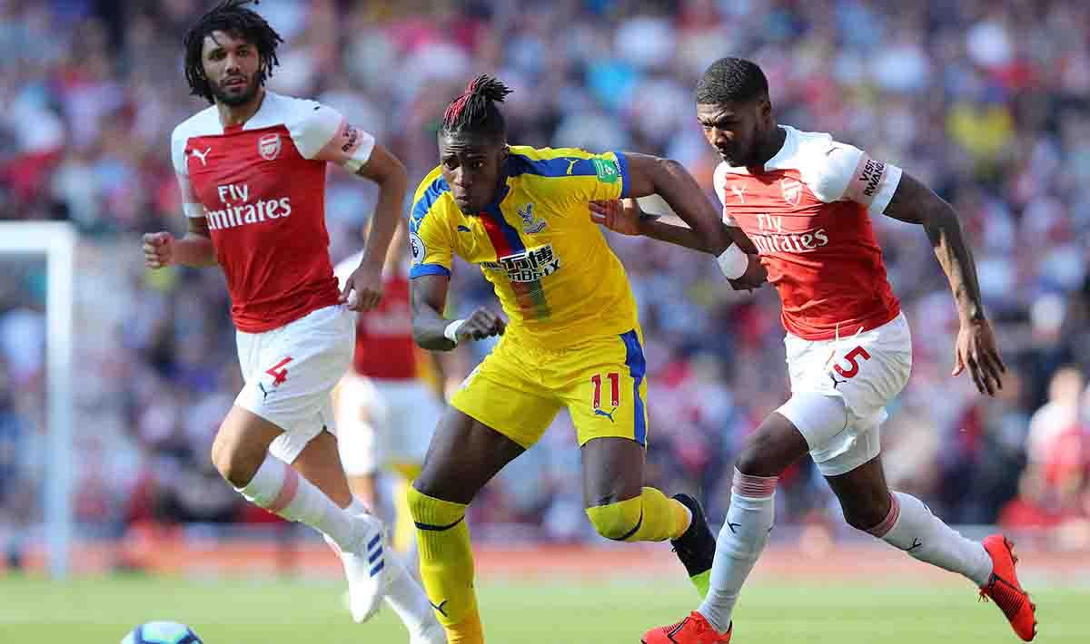 Wilfried Zaha dikawal ketat pemain Arsenal Ainsley Maitland-Niles dan Mohamed Elneny pada laga laga Liga Primer Inggris di Emirates Stadium, Senin 21/04/19. Warren Little/Getty Images