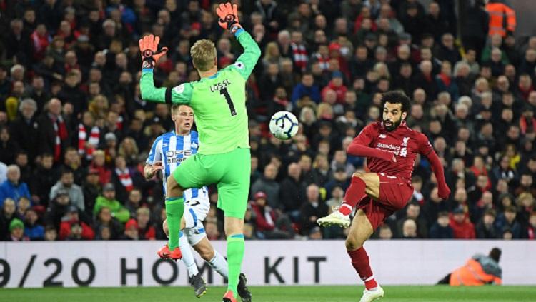 Aksi Mohamed Salah mengecoh penjaga gawang Huddersfield, Lossl, pada laga pekan ke-36 Liga Primer Inggris, Sabtu (27/04/19). Michael Regan/Getty Images. Copyright: Michael Regan/Getty Images