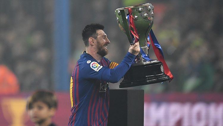Lionel Messi mengangkat trofi LaLiga 2018/19 yang berhasil dimenangkan Barcelona.