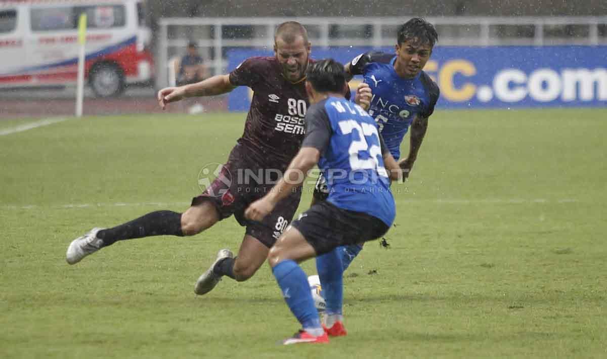 Wiljan Pluim saat akan mengeksekusi bola dari serangan dua pemain Home United. Herry Ibrahim/INDOSPORT Copyright: Herry Ibrahim/INDOSPORT