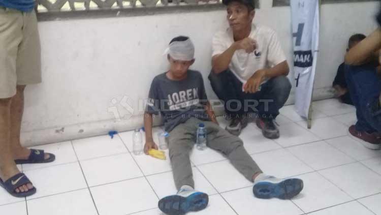 Salah satu bocah jadi korban pelemparan aksi suporter PSS Sleman vs Arema FC. Copyright: Ronald Seger Prabowo/INDOSPORT
