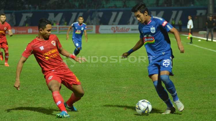 Septian David Maulana tengah mengontrol bola di hadapan pemain Kalteng Putra. Ronald Seger Prabowo/INDOSPORT