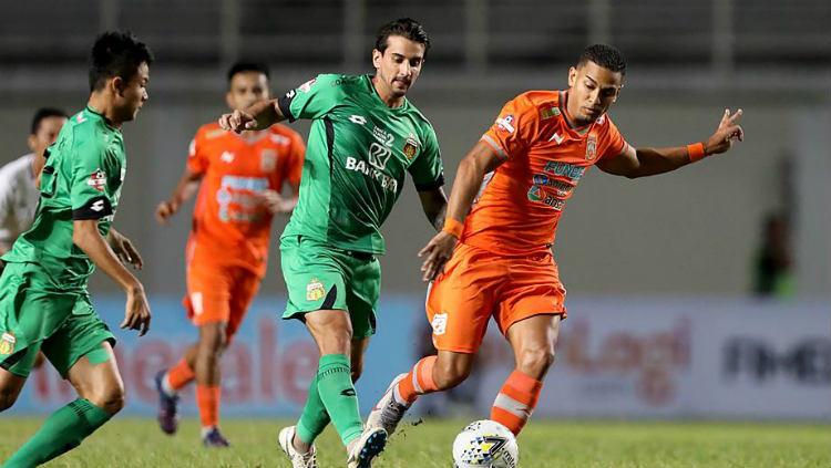 Dua pemain Bhayangkara FC berusaha merebut bola dari kaki pemain Borneo FC. Copyright: liga-indonesia.id