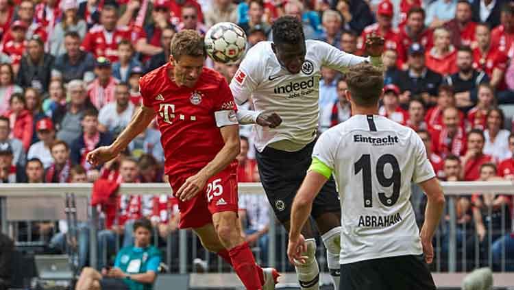 Duel udara dari pemain Bayern Munchen, Thomas Mueller dengan Gelson Fernandes, penggawa Eintracht Frankfurt