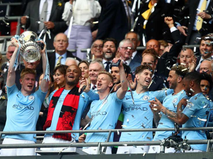 Para pemain Man City sedang mengangkat trofi Piala FA. Copyright: Julian Finney/Getty Images