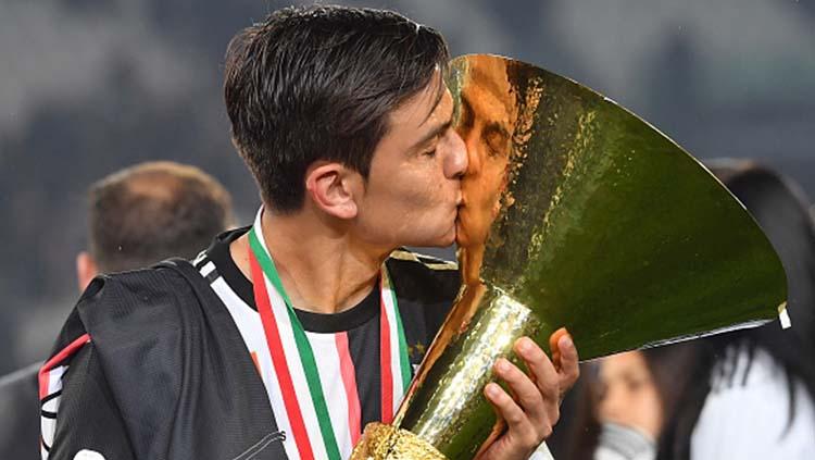 Paulo Dybala mencium trofi Serie A Italia Juventus sebagai juara musim ini. Tullio M. Puglia/Getty Images