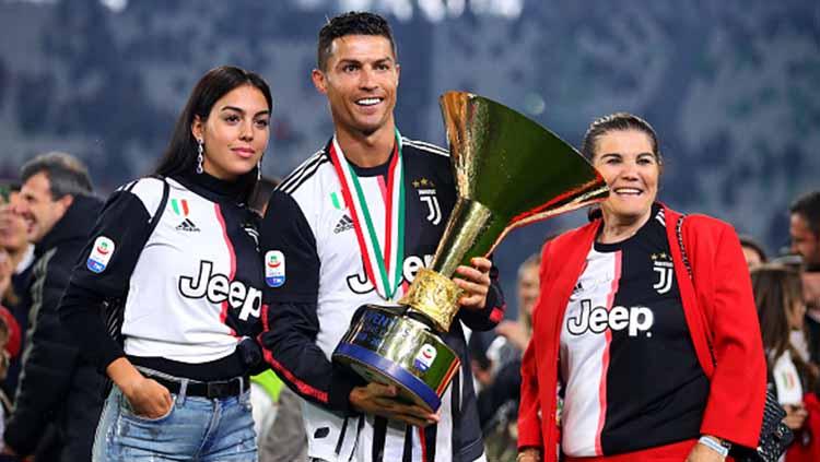 Cristiano Ronaldo pose bersama trofi Serie A Italia dengan pacarnya Georgina Rodriguez (kiri) dan ibunya Maria Dolores dos Santos Aveiro. Chris Brunskill/Fantasista/Getty Images