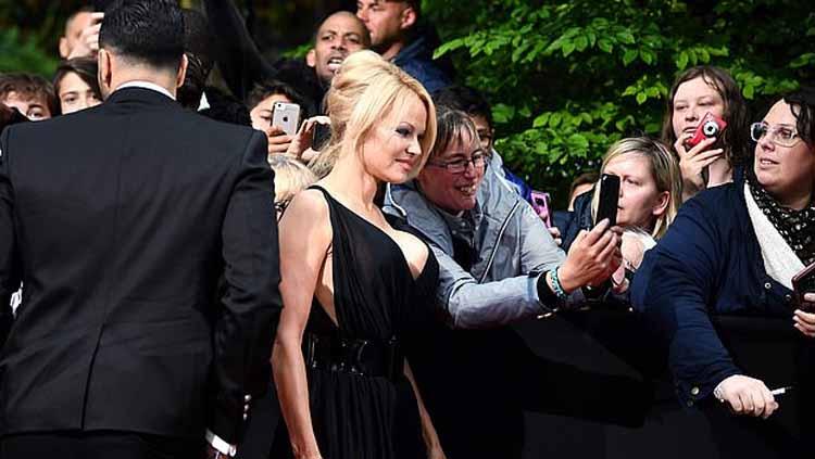 Bintang film Pamela Anderson bersama kekasihnya yang memperkuat Marseille, Adil Rami Copyright: AFP/Getty Images