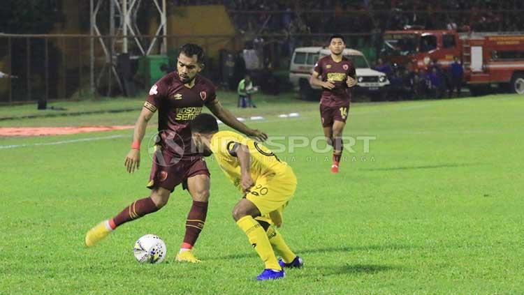 Zulham Zamrun akan mengeksekusi bola dari serangan pemain Semen Padang. Copyright: Wira Wahyu Utama/INDOSPORT