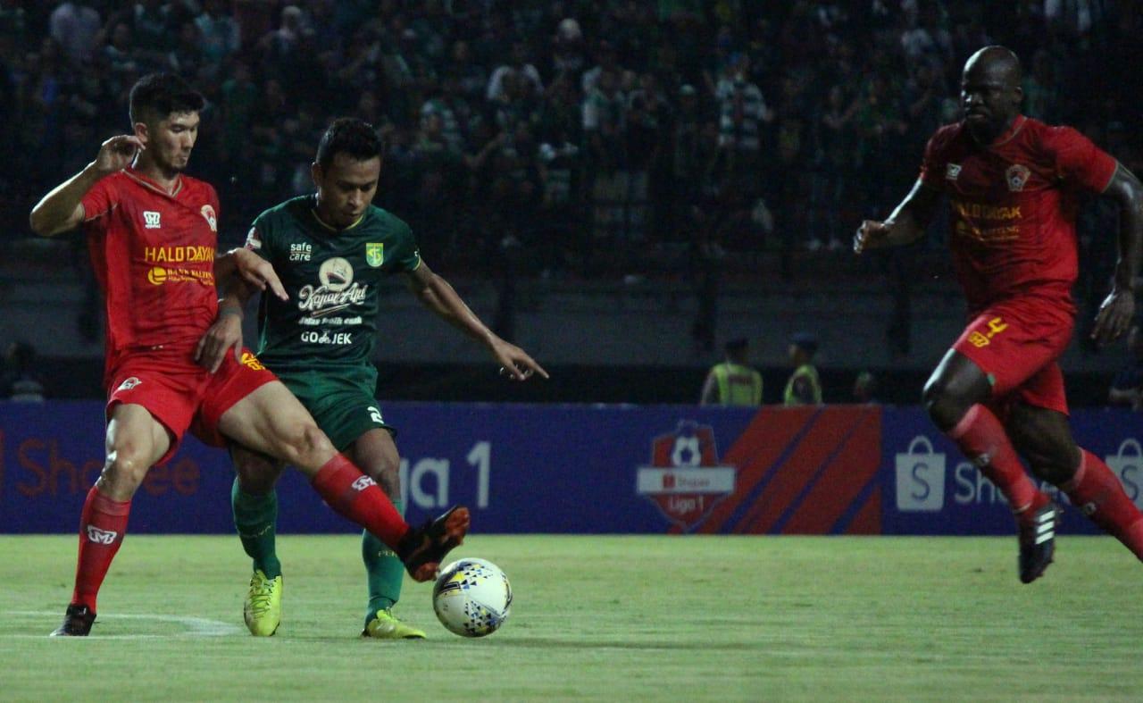 Osvaldo Haay (kedua dari kiri) tengah mengontrol bola sambil dibayangi pemain Kalteng Putra.